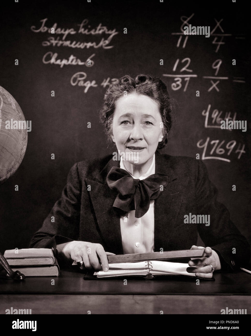 1940s-smiling-middle-aged-school-teacher-at-desk-beside-globe-holding-ruler-looking-at-camera-math-on-blackboard-s11689-har001-hars-females-ladies-persons-inspiration-caring-confidence-expressions-bw-mathematics-eye-contact-nice-head-and-shoulders-cheerful-strength-ruler-knowledge-powerful-stern-pride-at-on-authority-occupations-smiles-strict-beside-joyful-old-maid-problems-stylish-middle-age-pleasant-mid-adult-mid-adult-woman-precision-prissy-black-and-white-caucasian-ethnicity-har001-old-fashioned-severe-PND6A0.jpg