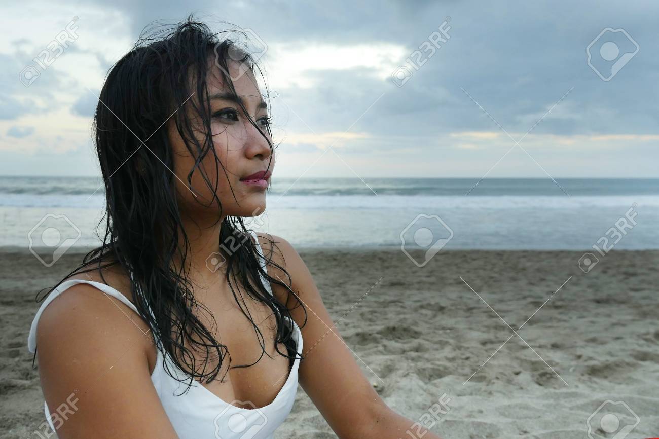 87255008-sea-landscape-portrait-of-young-beautiful-asian-girl-with-wet-hair-at-sunset-beach-looking-in-the-di.jpg