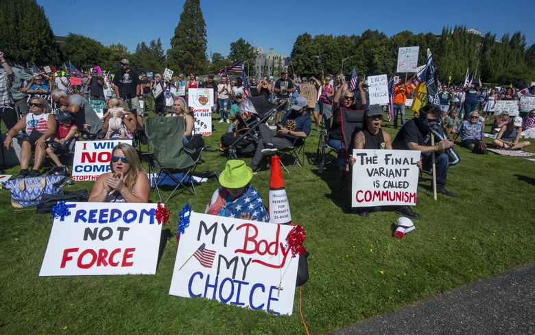 People gather outside the Capitol to protest Gov. Jay Inslee’s vaccine mandate for state workers Saturday in Olympia. (Drew Perine / The Associated Press)