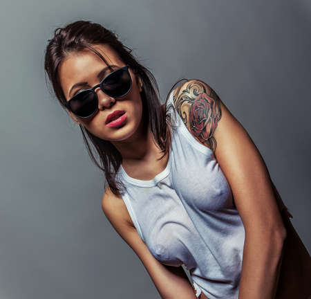 96457632-attractive-tatto-girl-in-white-wet-t-shirt.jpg